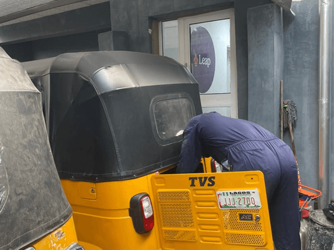 Mechanic working on yellow tricycle