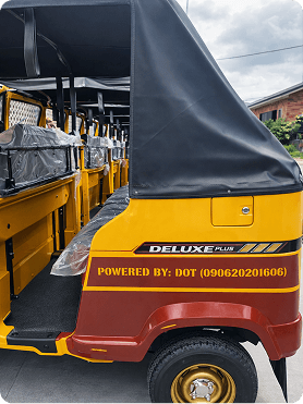 Yellow tricycle with DELUXE PLUS and POWERED BY DOT text